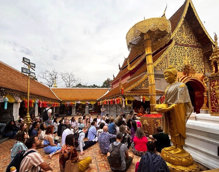 Visitors seated on the terrace in front of the viharn during a ceremony at Doi Suthep