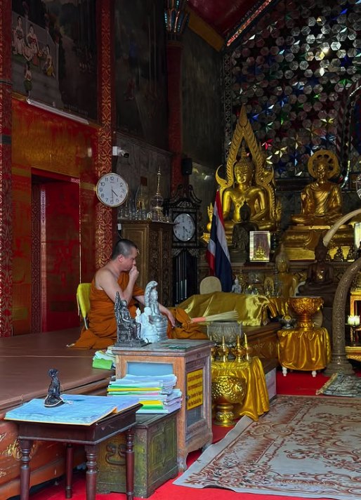 Gold Buddha images and offering trays inside a shrine hall at Doi Suthep