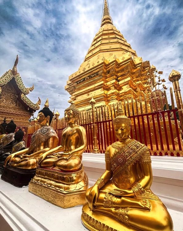 A row of gold Buddha images along the cloister in front of the chedi at Doi Suthep