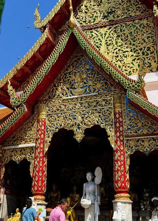 The red and gold Lanna viharn at Doi Suthep with its carved gable and stepped roofs
